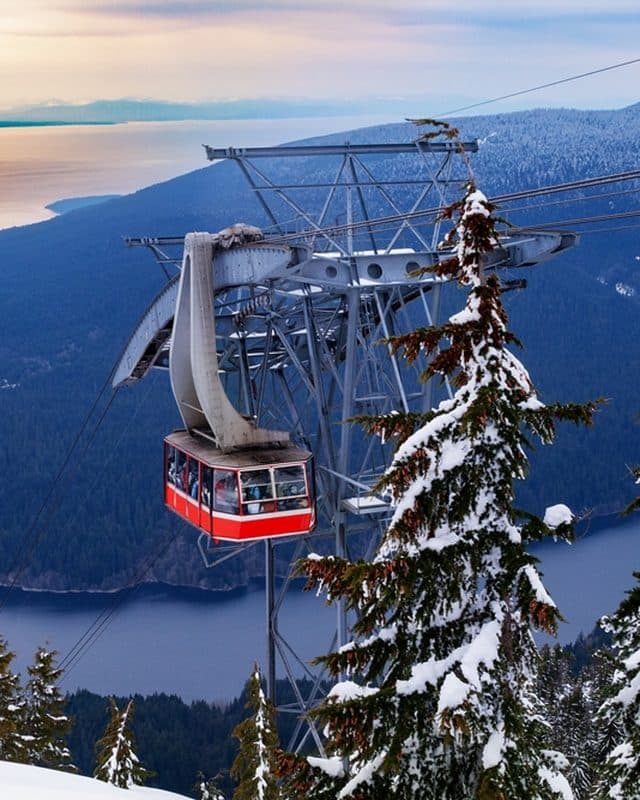The Grouse Mountain Skyride over snowy forest, the city, and the Salish Sea