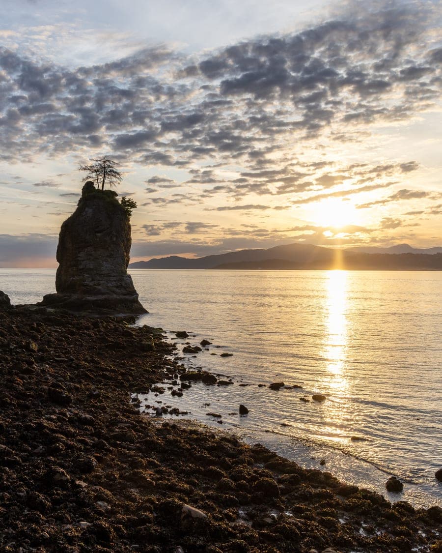Siwash Rock from the Stanley Park shoreline at sunset