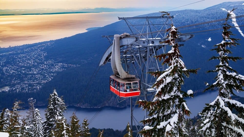 The Grouse Mountain Skyride over snowy forest, the city, and the Salish Sea