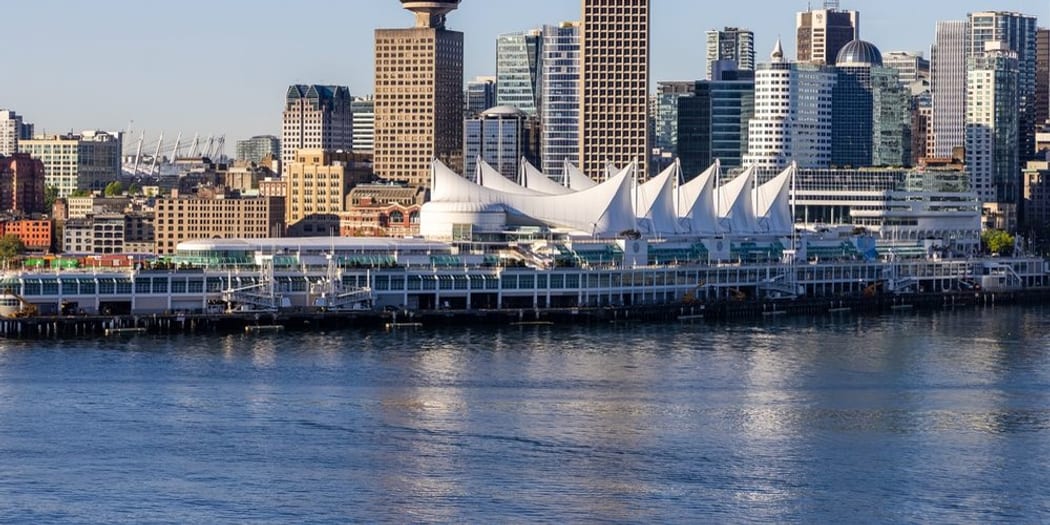 Canada Place sails on the harbour with the downtown skyline behind
