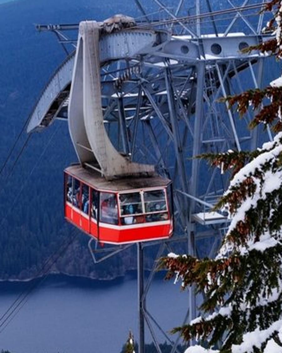 The Grouse Mountain Skyride over snowy forest, the city, and the Salish Sea