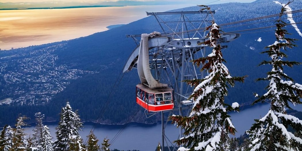 The Grouse Mountain Skyride over snowy forest, the city, and the Salish Sea