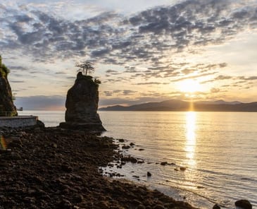 Siwash Rock from the Stanley Park shoreline at sunset