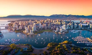 Downtown Vancouver from the air at sunset, with False Creek sailboats, Stanley Park, and the North Shore mountains